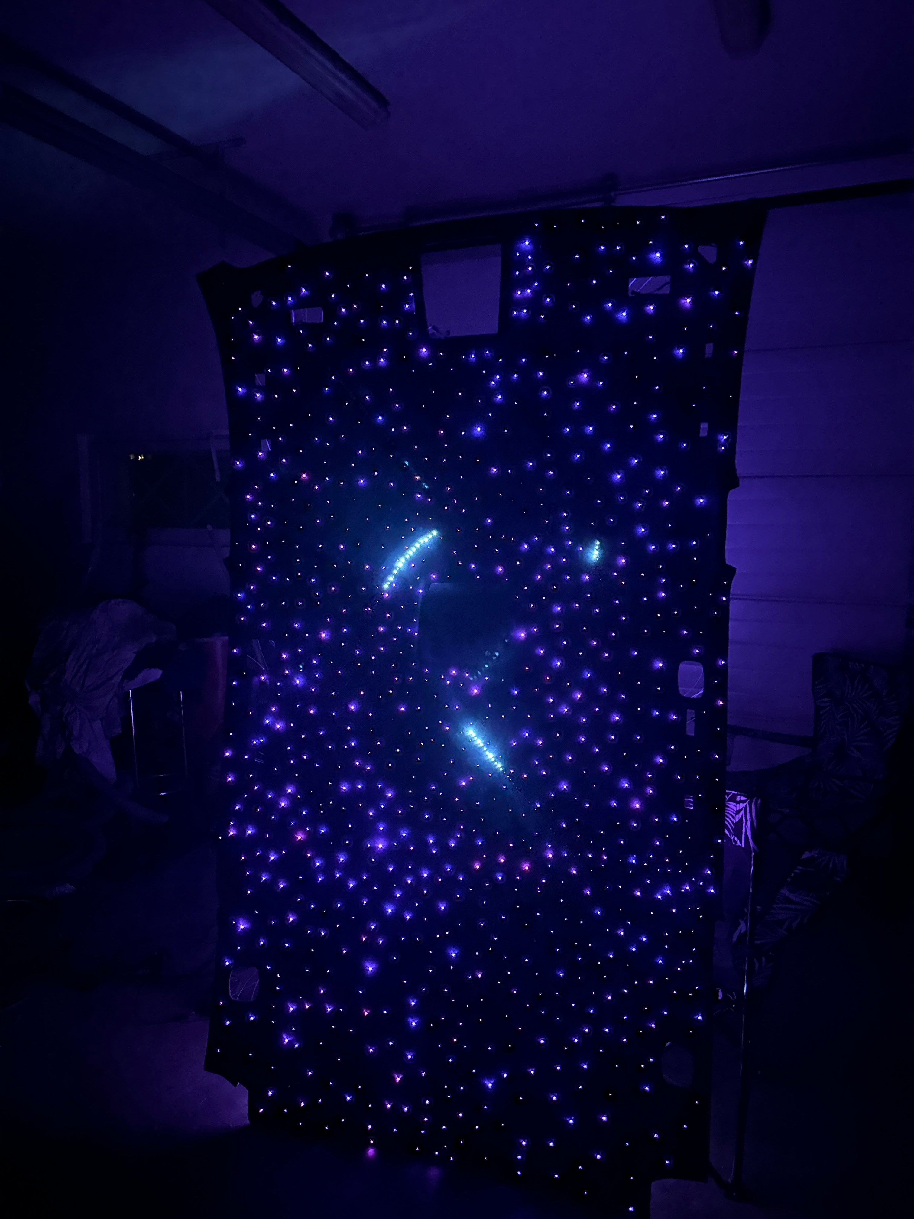 Starry night sky fabric with embedded LED lights in a dark room