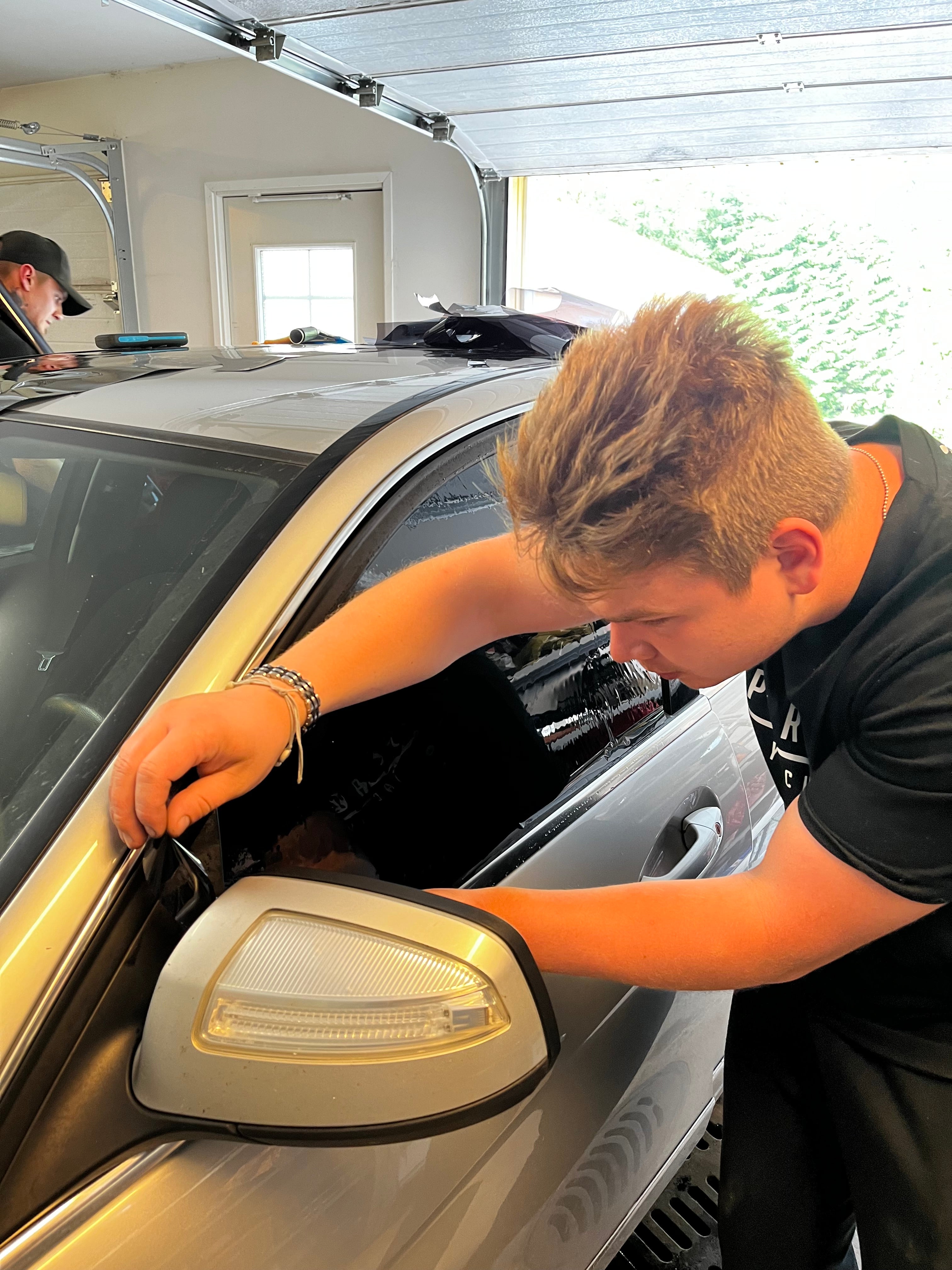 Person replacing a car mirror on a vehicle